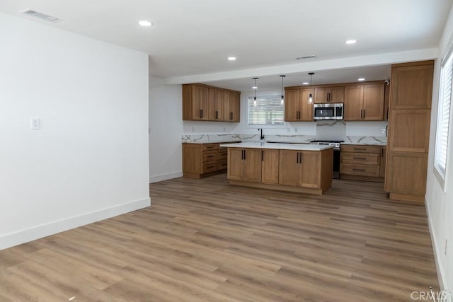8666 Calaveras Ave, Rancho Cucamonga, CA 91730 - kitchen with stainless steel appliances, brown cabinetry, light countertops, light wood finished floors, and recessed lighting