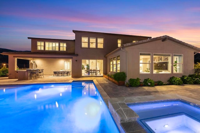 2990Eldenberry St, Escondido, CA 92029 - back of house at dusk with an in-ground hot tub, a patio, an outdoor pool, and stucco siding