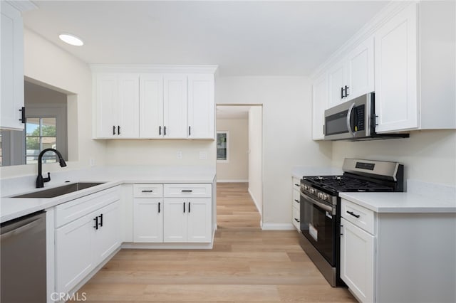 880 E Wright St, Hemet, CA 92543 - kitchen with stainless steel appliances, white cabinetry, light wood-style floors, and light countertops