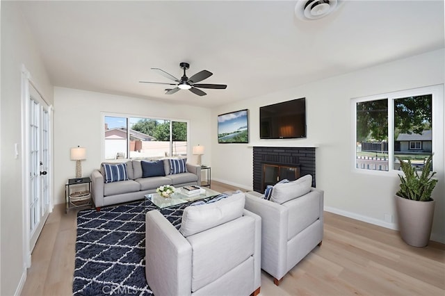 880 E Wright St, Hemet, CA 92543 - living room featuring light wood-style flooring, ceiling fan, and a brick fireplace