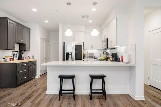 101 Red Brick Dr Unit 5, Simi Valley, CA 93065 - kitchen featuring appliances with stainless steel finishes, a peninsula, light wood-type flooring, light countertops, and recessed lighting