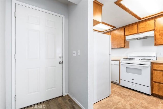 10710 El Camino Real Unit 14, Atascadero, CA 93422 - kitchen with under cabinet range hood, white appliances, brown cabinets, and light countertops