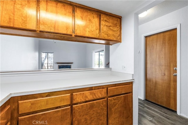 10710 El Camino Real Unit 14, Atascadero, CA 93422 - kitchen with light countertops, dark wood-style floors, a fireplace, and brown cabinets