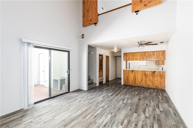 10710 El Camino Real Unit 14, Atascadero, CA 93422 - unfurnished living room with a towering ceiling, wood finished floors, stairway, and ceiling fan