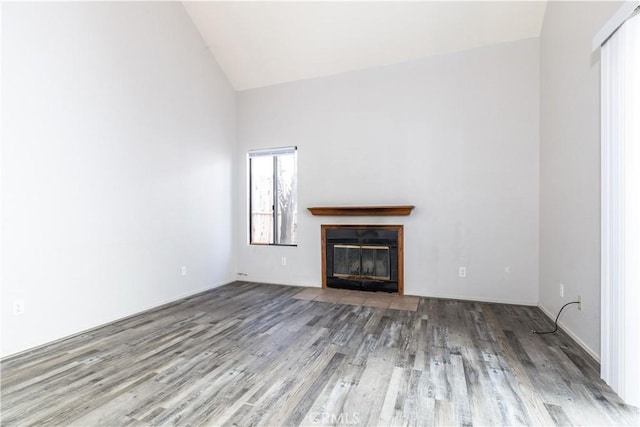 10710 El Camino Real Unit 14, Atascadero, CA 93422 - unfurnished living room featuring wood finished floors, a fireplace with flush hearth, and high vaulted ceiling