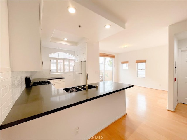 1628 E Palm Ave Unit 5, El Segundo, CA 90245 - kitchen featuring freestanding refrigerator, light wood-type flooring, tasteful backsplash, white cabinetry, and a peninsula