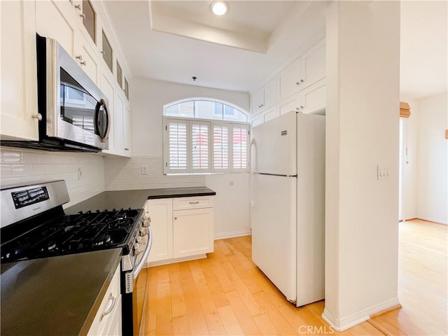 1628 E Palm Ave Unit 5, El Segundo, CA 90245 - kitchen featuring appliances with stainless steel finishes, dark countertops, light wood-style flooring, white cabinets, and backsplash