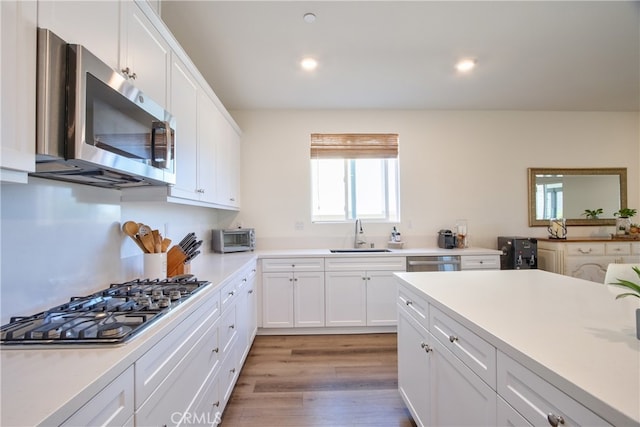 33084 Toledo Bend Ct, Winchester, CA 92596 - kitchen with stainless steel appliances, white cabinets, light wood-style floors, light countertops, and recessed lighting