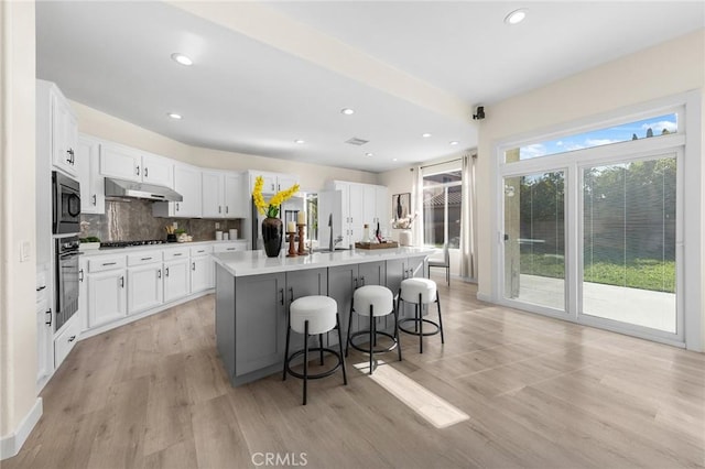 18680 Vantage Pointe Dr, Rowland Heights, CA 91748 - kitchen featuring under cabinet range hood, built in microwave, stainless steel oven, gas stovetop, and light wood-style flooring