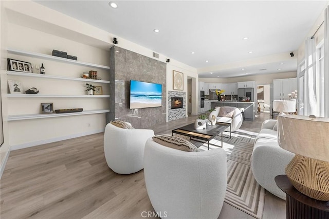 18680 Vantage Pointe Dr, Rowland Heights, CA 91748 - living room with light wood-type flooring, built in features, a fireplace, and recessed lighting
