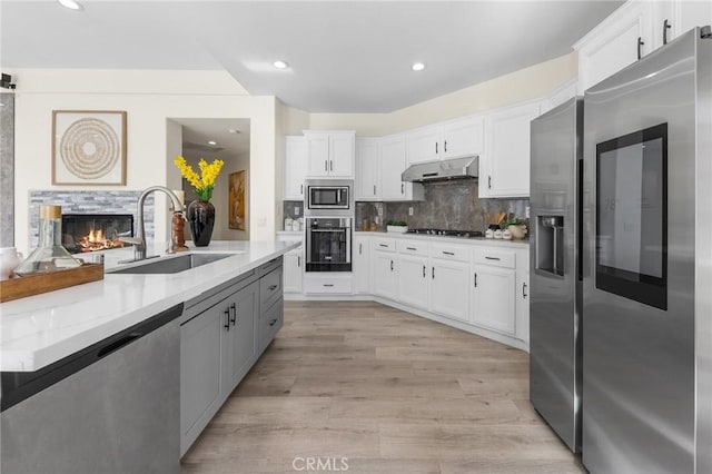 18680 Vantage Pointe Dr, Rowland Heights, CA 91748 - kitchen featuring stainless steel appliances, under cabinet range hood, light countertops, white cabinets, and decorative backsplash