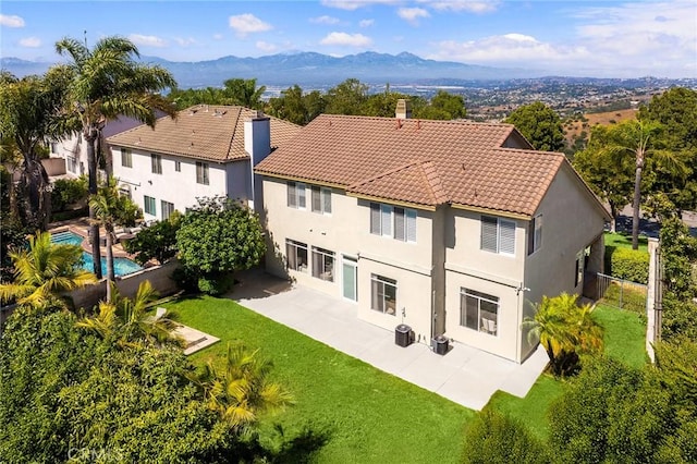 18680 Vantage Pointe Dr, Rowland Heights, CA 91748 - rear view of house featuring a chimney, a patio, a fenced backyard, a mountain view, and stucco siding