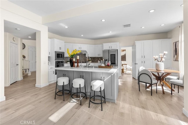 18680 Vantage Pointe Dr, Rowland Heights, CA 91748 - kitchen with appliances with stainless steel finishes, white cabinetry, light countertops, light wood finished floors, and recessed lighting