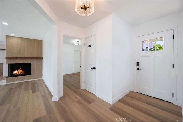 11251 Bowles Ave, Garden Grove, CA 92841 - entryway featuring light wood finished floors, a large fireplace, recessed lighting, and a chandelier
