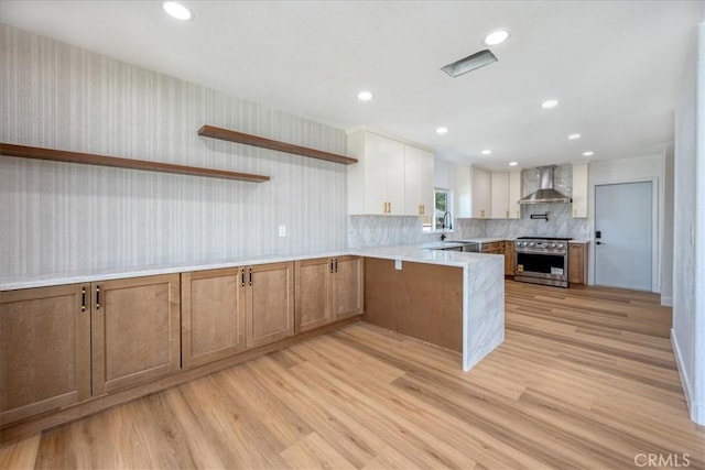 11251 Bowles Ave, Garden Grove, CA 92841 - kitchen featuring wall chimney range hood, stainless steel stove, a peninsula, open shelves, and light wood-style floors