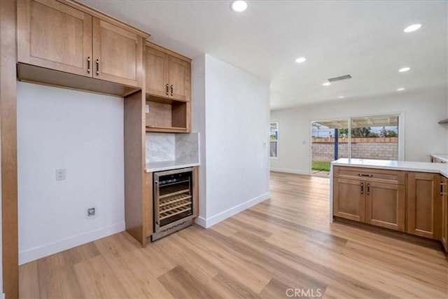 11251 Bowles Ave, Garden Grove, CA 92841 - kitchen with wine cooler, light wood finished floors, recessed lighting, light countertops, and decorative backsplash