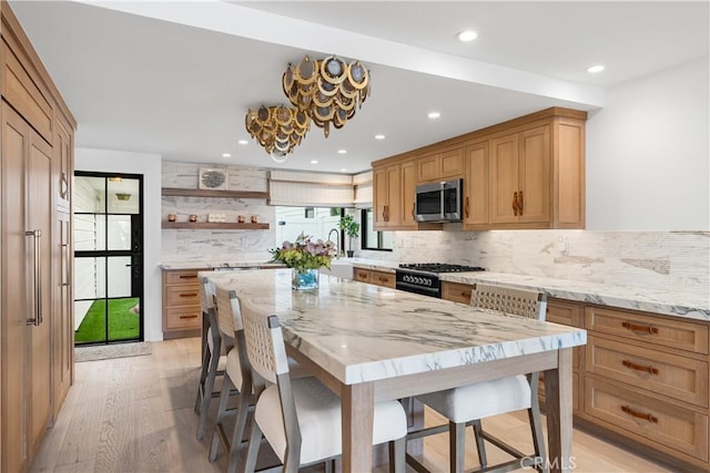 1817 W Bay Ave Unit A, Newport Beach, CA 92663 - kitchen featuring stainless steel microwave, a breakfast bar area, black gas range oven, open shelves, and tasteful backsplash