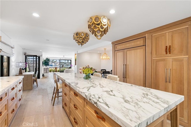 1817 W Bay Ave Unit A, Newport Beach, CA 92663 - kitchen featuring paneled built in refrigerator, recessed lighting, light stone counters, a breakfast bar area, and light wood-type flooring