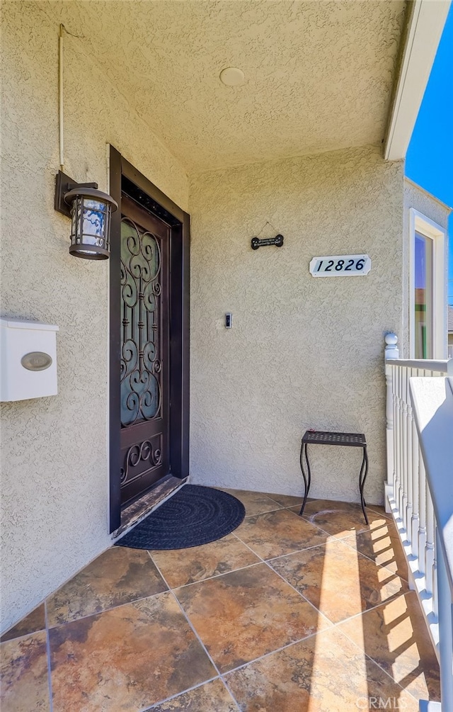 12826 Bombardier Ave, Norwalk, CA 90650 - doorway to property with stucco siding and a balcony