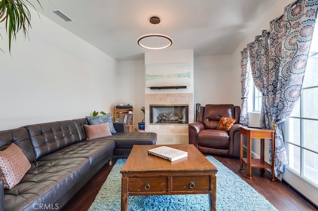 12826 Bombardier Ave, Norwalk, CA 90650 - living area featuring dark wood finished floors, healthy amount of natural light, a tile fireplace, and lofted ceiling