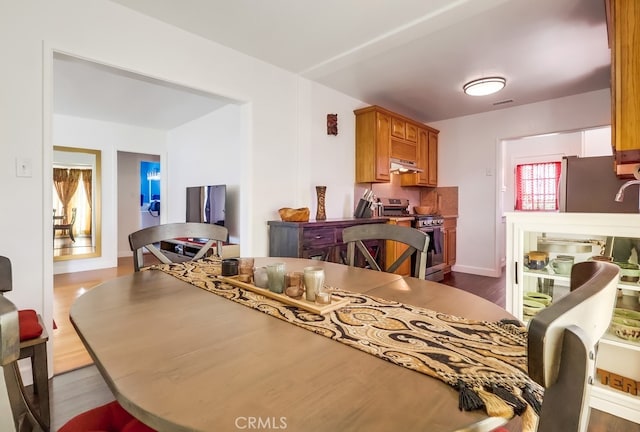 12826 Bombardier Ave, Norwalk, CA 90650 - dining space with dark wood-type flooring and baseboards