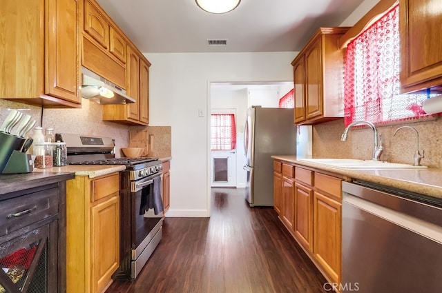 12826 Bombardier Ave, Norwalk, CA 90650 - kitchen featuring stainless steel appliances, ventilation hood, dark wood-style floors, and decorative backsplash