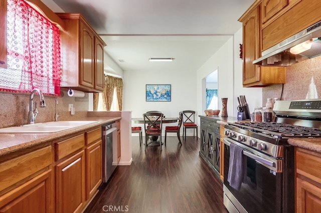 12826 Bombardier Ave, Norwalk, CA 90650 - kitchen featuring stainless steel appliances, under cabinet range hood, decorative backsplash, and dark wood finished floors