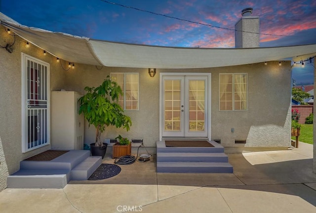 12826 Bombardier Ave, Norwalk, CA 90650 - property entrance featuring french doors, stucco siding, and a chimney