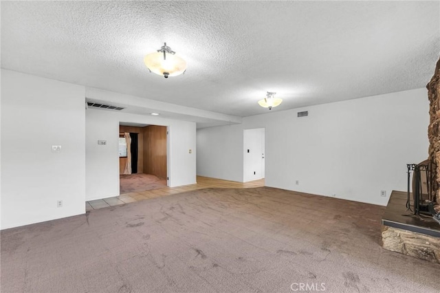 13624 Vose St, Valley Glen, CA 91405 - unfurnished living room with carpet flooring, a textured ceiling, and a wood stove