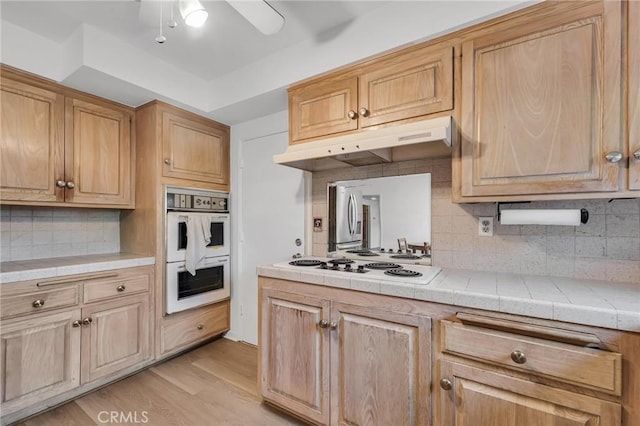 13624 Vose St, Valley Glen, CA 91405 - kitchen featuring white appliances, under cabinet range hood, decorative backsplash, ceiling fan, and light wood-style floors