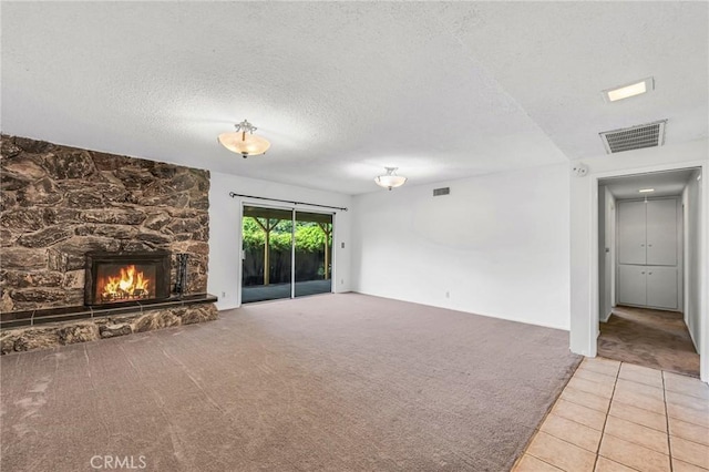 13624 Vose St, Valley Glen, CA 91405 - unfurnished living room featuring carpet, a stone fireplace, a textured ceiling, and tile patterned floors