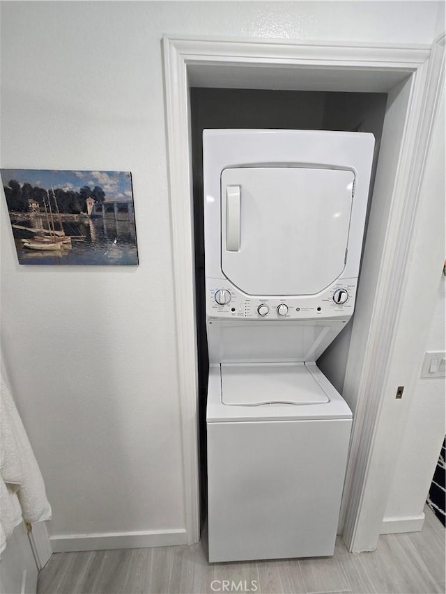 200 Pacific Coast Unit 130, Huntington Beach, CA 92648 - washroom featuring stacked washer / drying machine and light wood finished floors