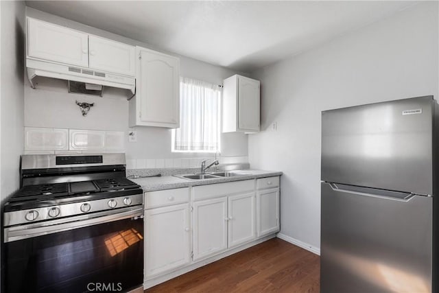 11001 Duncan Ave, Lynwood, CA 90262 - kitchen with stainless steel appliances, under cabinet range hood, dark wood finished floors, white cabinetry, and light countertops