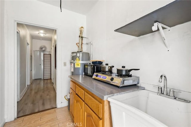 213 S Atlantic Blvd, Alhambra, CA 91801 - kitchen featuring light wood-type flooring, water heater, brown cabinetry, and stainless steel cooktop