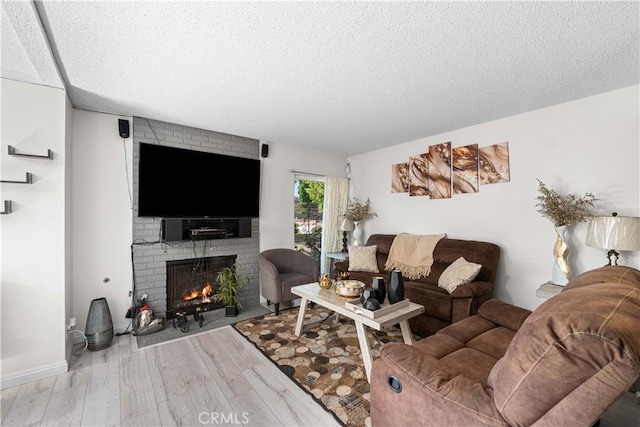 15060 Chatsworth St Unit E, San Fernando, CA 91345 - living room with a textured ceiling, a fireplace, and wood finished floors