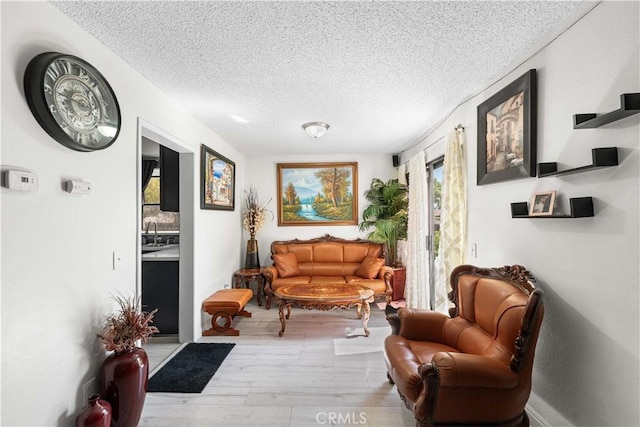 15060 Chatsworth St Unit E, San Fernando, CA 91345 - sitting room with a textured ceiling and wood finished floors