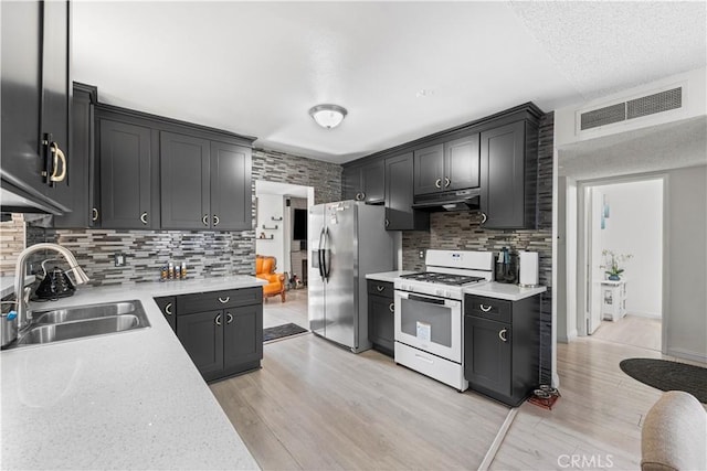 15060 Chatsworth St Unit E, San Fernando, CA 91345 - kitchen featuring white gas range oven, stainless steel fridge, light countertops, and backsplash