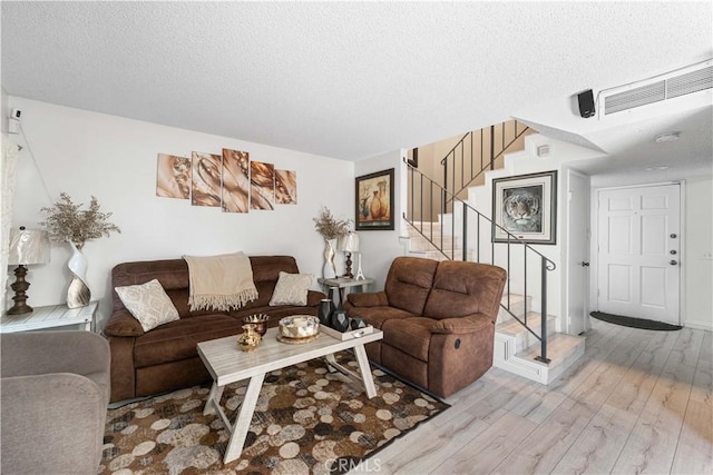 15060 Chatsworth St Unit E, San Fernando, CA 91345 - living area with light wood-type flooring, stairway, and a textured ceiling