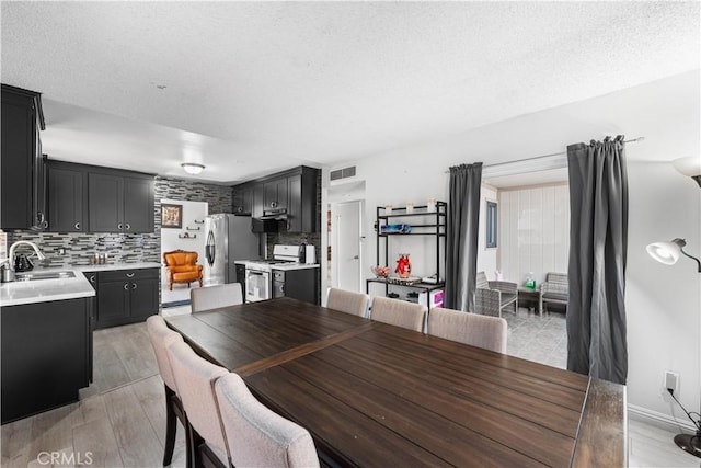 15060 Chatsworth St Unit E, San Fernando, CA 91345 - dining space featuring light wood-style flooring and a textured ceiling