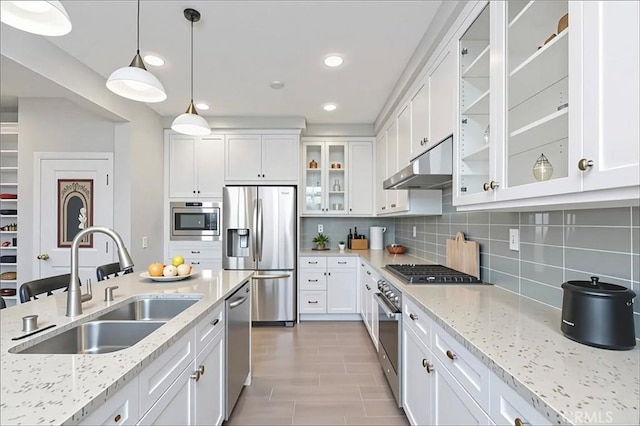 72 Granite, Irvine, CA 92620 - kitchen with stainless steel appliances, under cabinet range hood, white cabinets, decorative backsplash, and pendant lighting