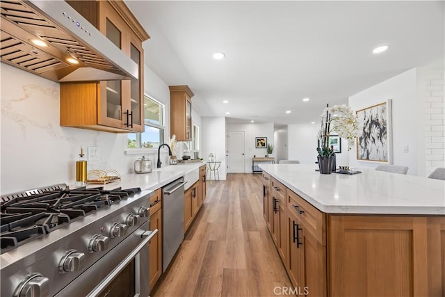 1809 Celeste Ln, Fullerton, CA 92833 - kitchen featuring stainless steel appliances, exhaust hood, brown cabinetry, light wood-style floors, and recessed lighting