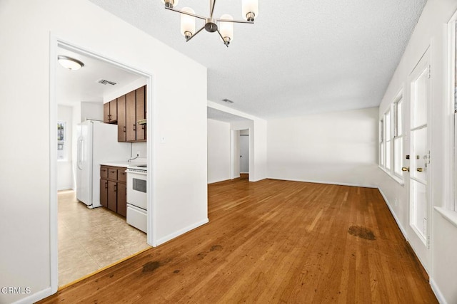 2056 Fulton Ave, Monterey Park, CA 91755 - unfurnished living room with a chandelier, light wood-style flooring, and a textured ceiling