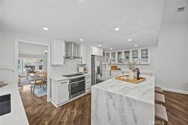6 Crockett, Irvine, CA 92620 - kitchen with stainless steel appliances, wall chimney exhaust hood, dark wood-type flooring, a center island, and recessed lighting
