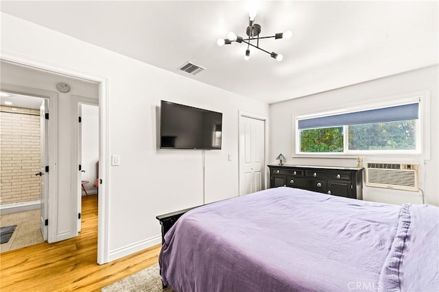 8110 True Ave, Pico Rivera, CA 90660 - bedroom with light wood finished floors, a chandelier, a closet, ensuite bathroom, and a wall mounted air conditioner