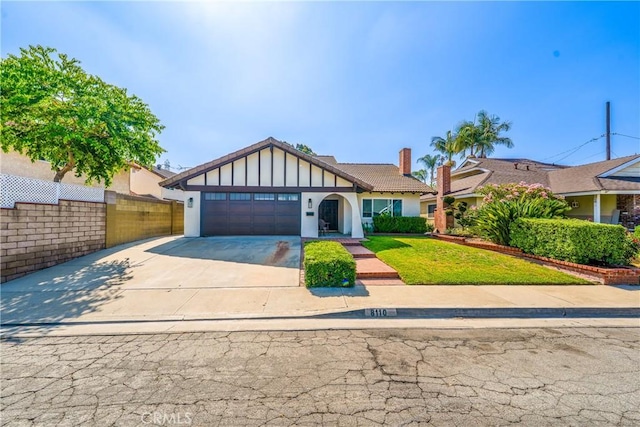8110 True Ave, Pico Rivera, CA 90660 - tudor-style house featuring an attached garage, concrete driveway, stucco siding, and a chimney