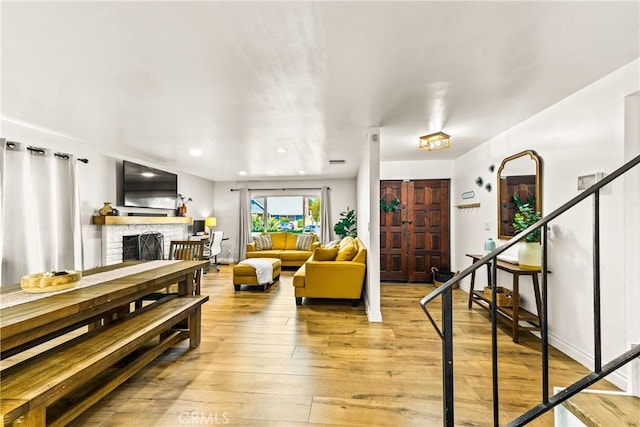 8110 True Ave, Pico Rivera, CA 90660 - living area with light wood-type flooring, a fireplace, stairs, and recessed lighting
