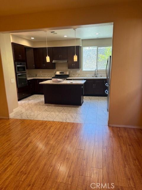 330 E Concord Way, Placentia, CA 92870 - kitchen featuring light countertops, a kitchen island, stainless steel appliances, light wood-style floors, and under cabinet range hood