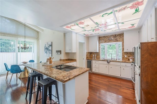 30243 Avenida Selecta, Rancho Palos Verdes, CA 90275 - kitchen featuring black electric stovetop, a chandelier, dark wood finished floors, and white cabinets