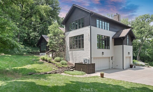 3530 Trimble Ct, Nashville, TN 37215 - view of side of home featuring a chimney, concrete driveway, a garage, a lawn, and stucco siding