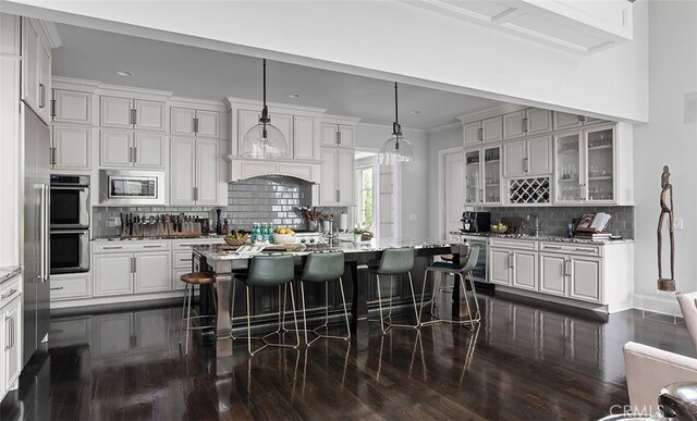 3530 Trimble Ct, Nashville, TN 37215 - kitchen featuring stainless steel appliances, dark wood finished floors, tasteful backsplash, a breakfast bar, and ornamental molding